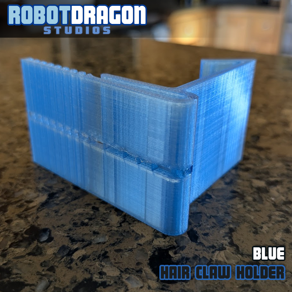 Angled bottom closeup of a 3D printed blue translucent PETG hair claw holder designed and created by Robot Dragon Studios for artist alley.