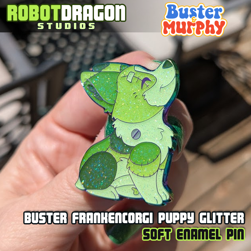 Angled close up photo of Buster Frankencorgi puppy enamel pin with rainbow metal finish and glitter effects by Robot Dragon Studios.
