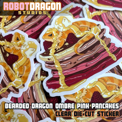Pile of clear die cut bearded dragon lizard on a pancake stickers from Robot Dragon Studios.