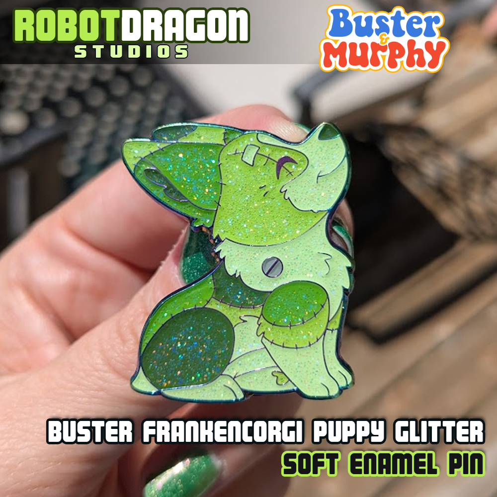 Front close up photo of Buster Frankencorgi puppy enamel pin with rainbow metal finish and glitter effects by Robot Dragon Studios.