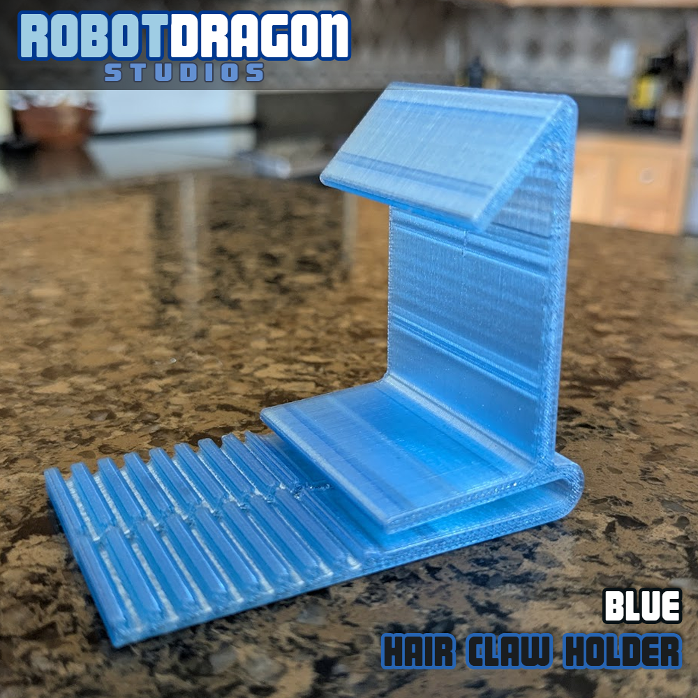Angled closeup of a 3D printed blue translucent PETG hair claw holder designed and created by Robot Dragon Studios for artist alley.