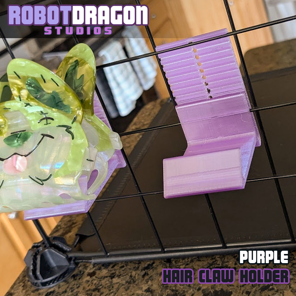Close up photo of two 3D printed purple translucent PETG hair claw holders designed and created by Robot Dragon Studios on a wire grid cube setup for artist alley.