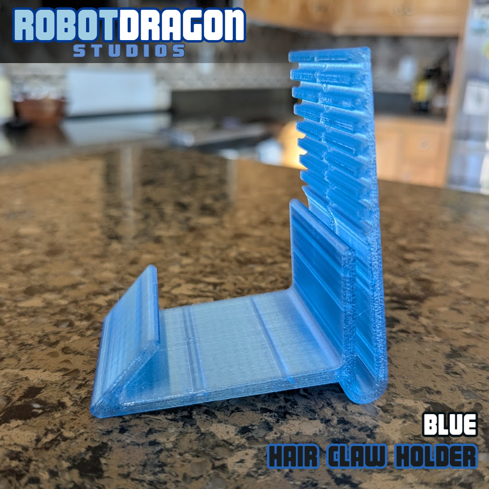 Sideview of a 3D printed blue translucent PETG hair claw holder designed and created by Robot Dragon Studios for artist alley.