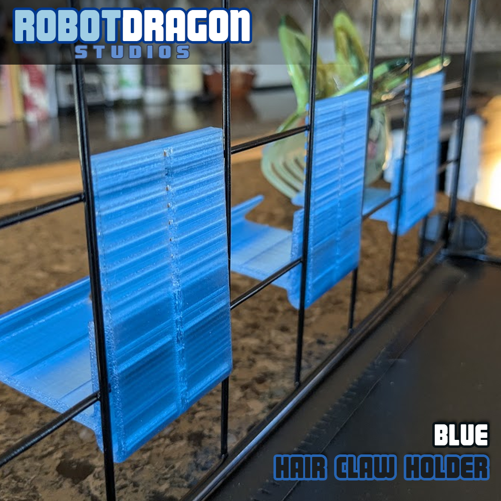 Backside close up photo of three 3D printed blue translucent PETG hair claw holders designed and created by Robot Dragon Studios on a wire grid cube setup for artist alley.