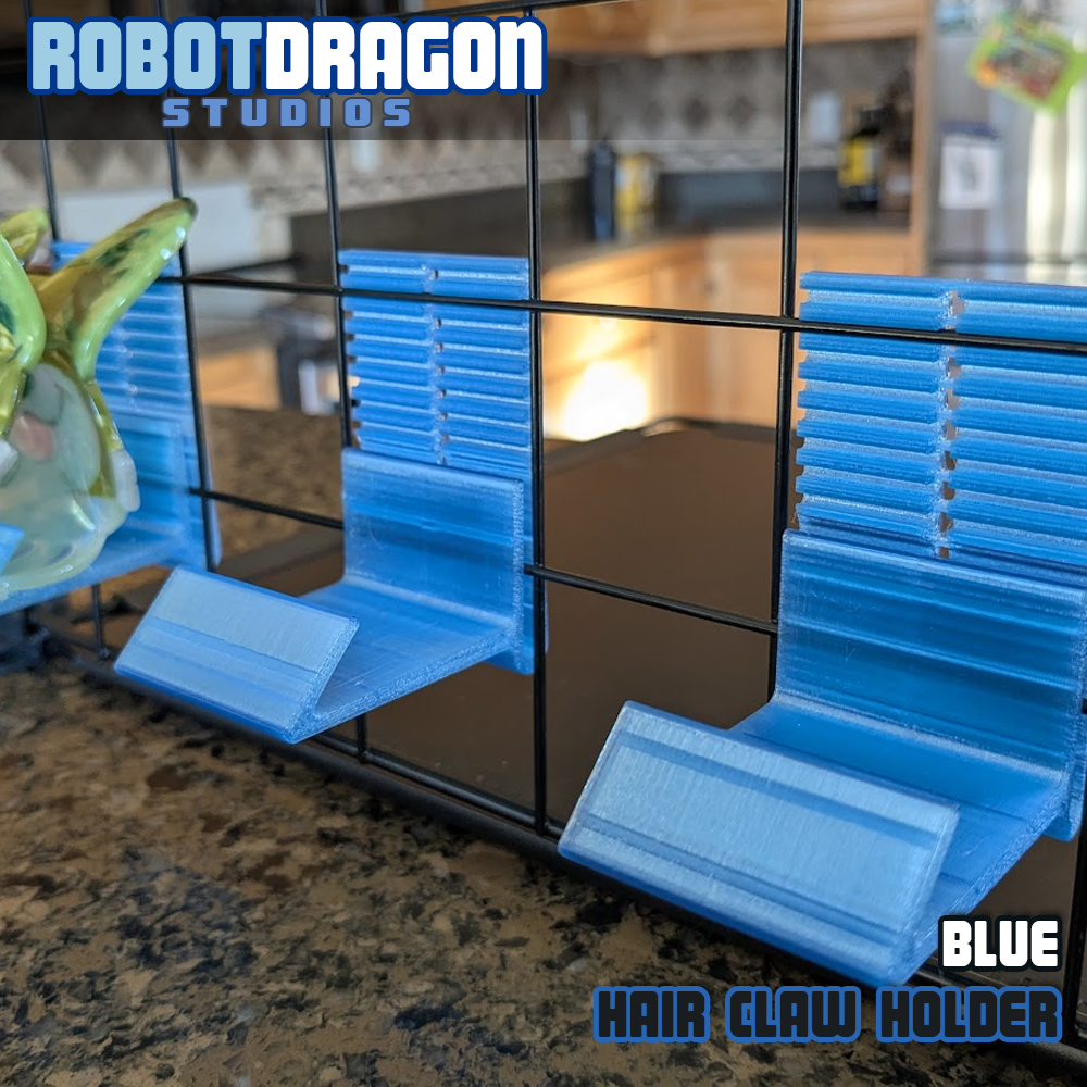 Close up photo of three 3D printed blue translucent PETG hair claw holders designed and created by Robot Dragon Studios on a wire grid cube setup for artist alley.