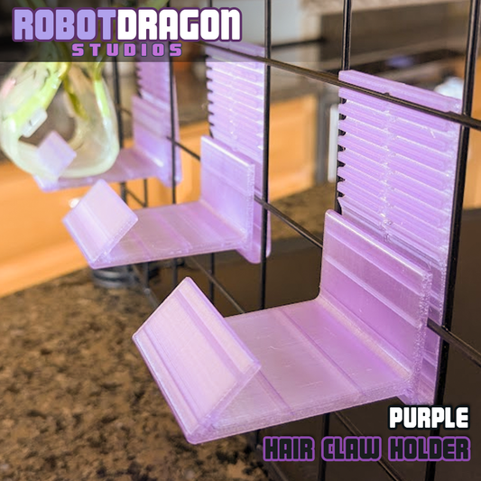 Close up photo of three 3D printed purple translucent PETG hair claw holders designed and created by Robot Dragon Studios on a wire grid cube setup for artist alley. 