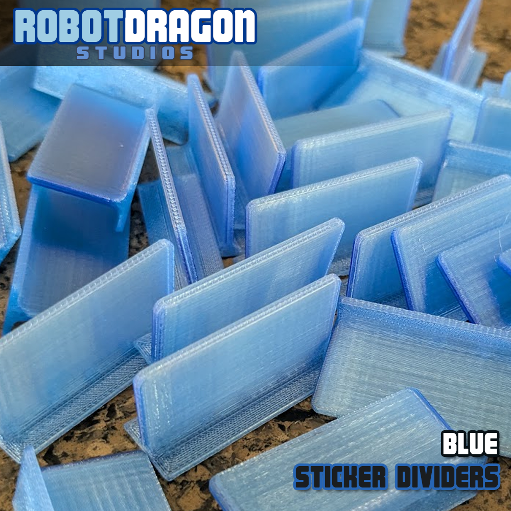 Close up photo of a messy pile of 3D printed blue translucent PETG sticker dividers designed and created by Robot Dragon Studios for artist alley.