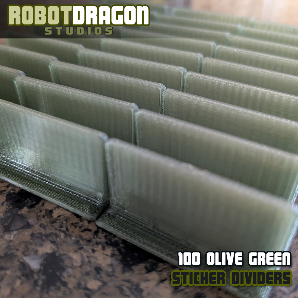Close up photo of a row of 3D printed olive green translucent PETG sticker dividers designed and created by Robot Dragon Studios for artist alley.