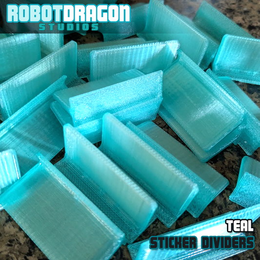 Close up photo of a messy pile of 3D printed teal translucent PETG sticker dividers designed and created by Robot Dragon Studios for artist alley.